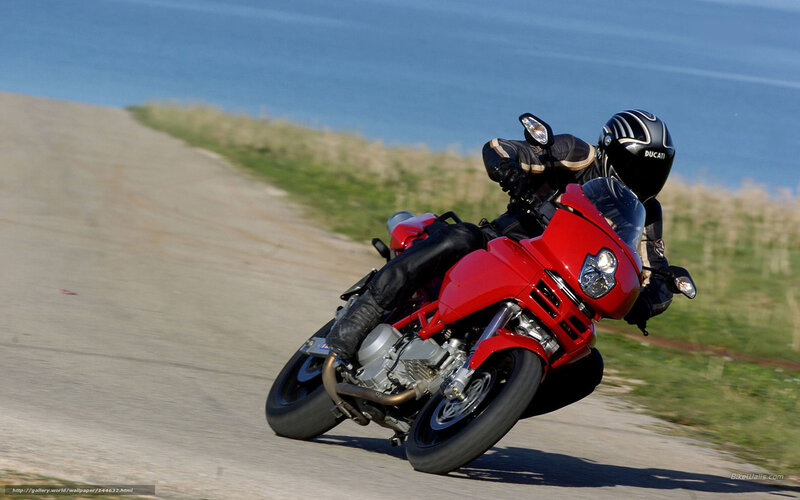 Riding a red motorcycle on a coastal road