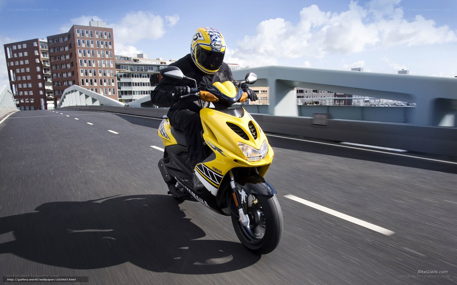 Riding a yellow scooter on a bridge