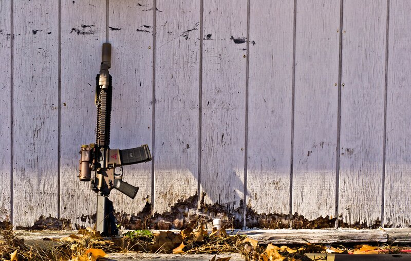 rifle against a weathered wall