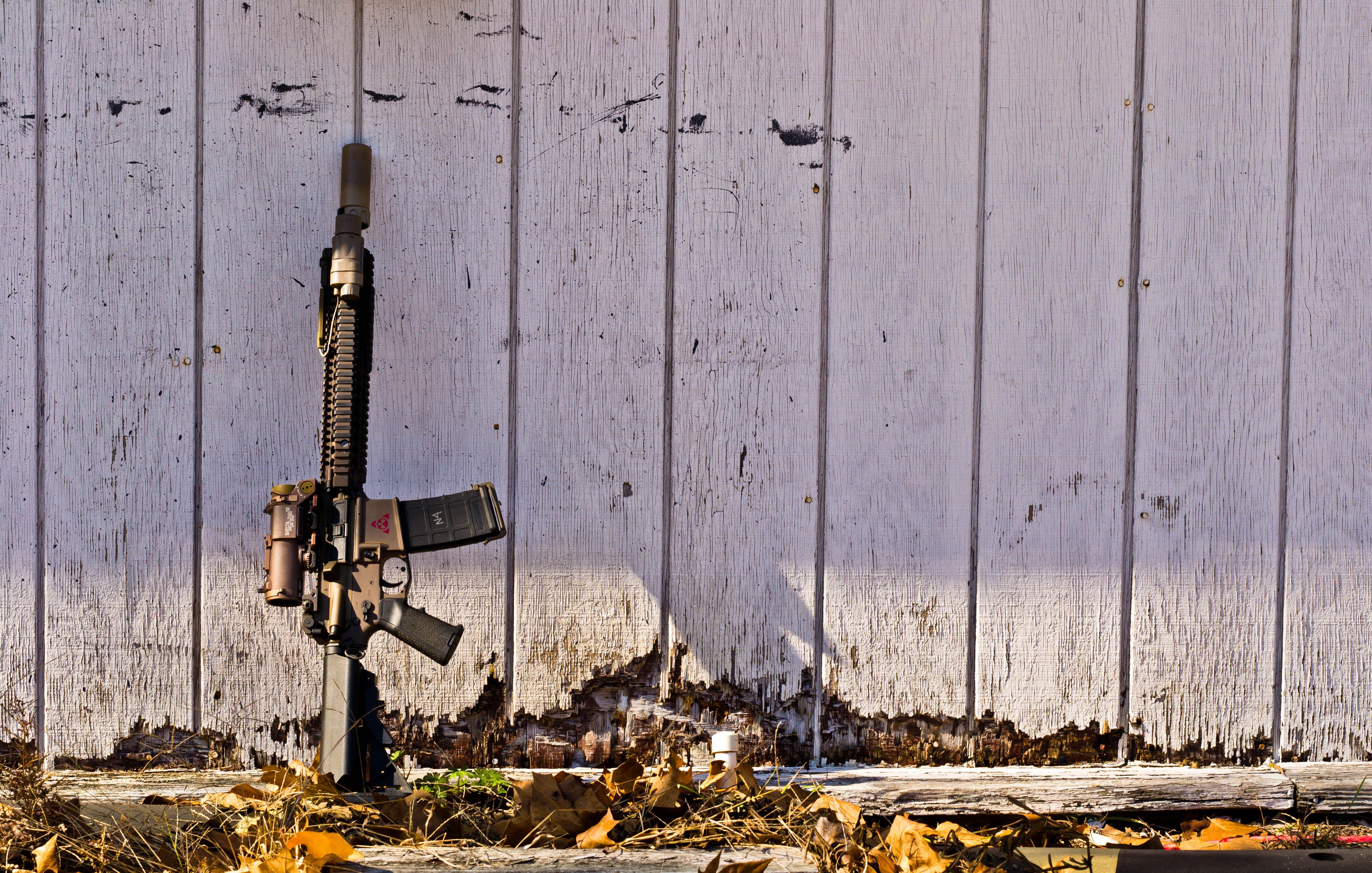 rifle against a weathered wall