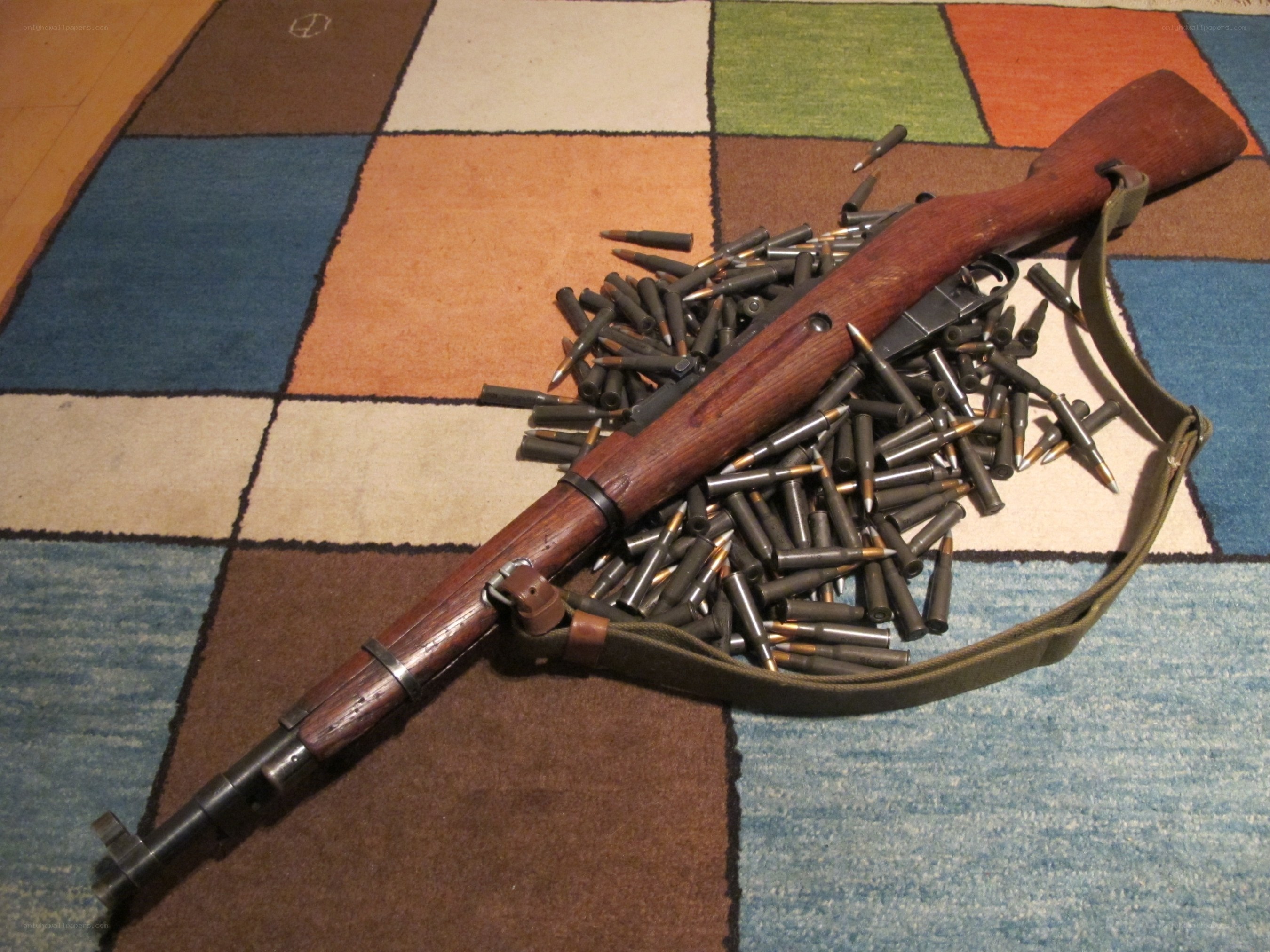 rifle with ammunition on rug
