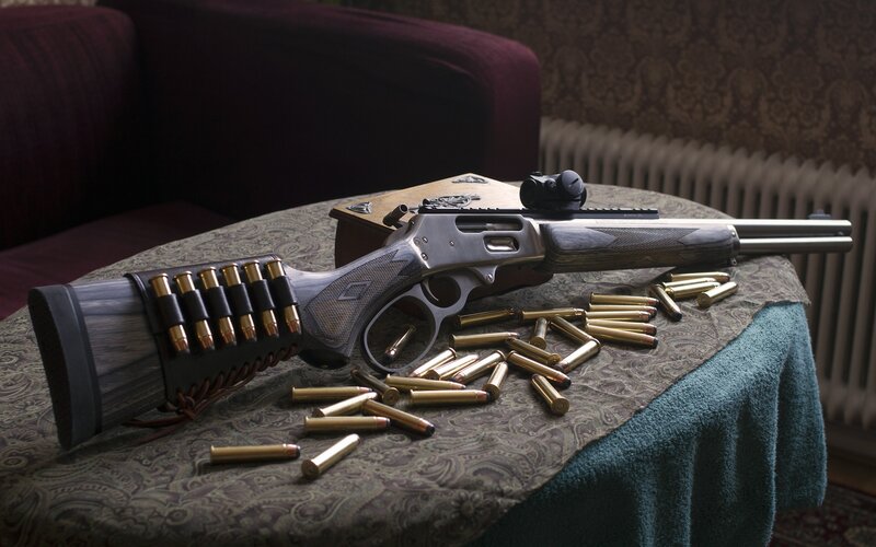 Rifle with ammunition on table