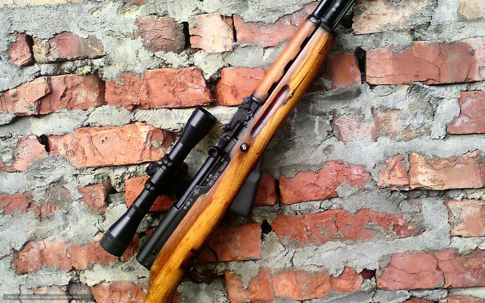 rifle with scope on brick wall