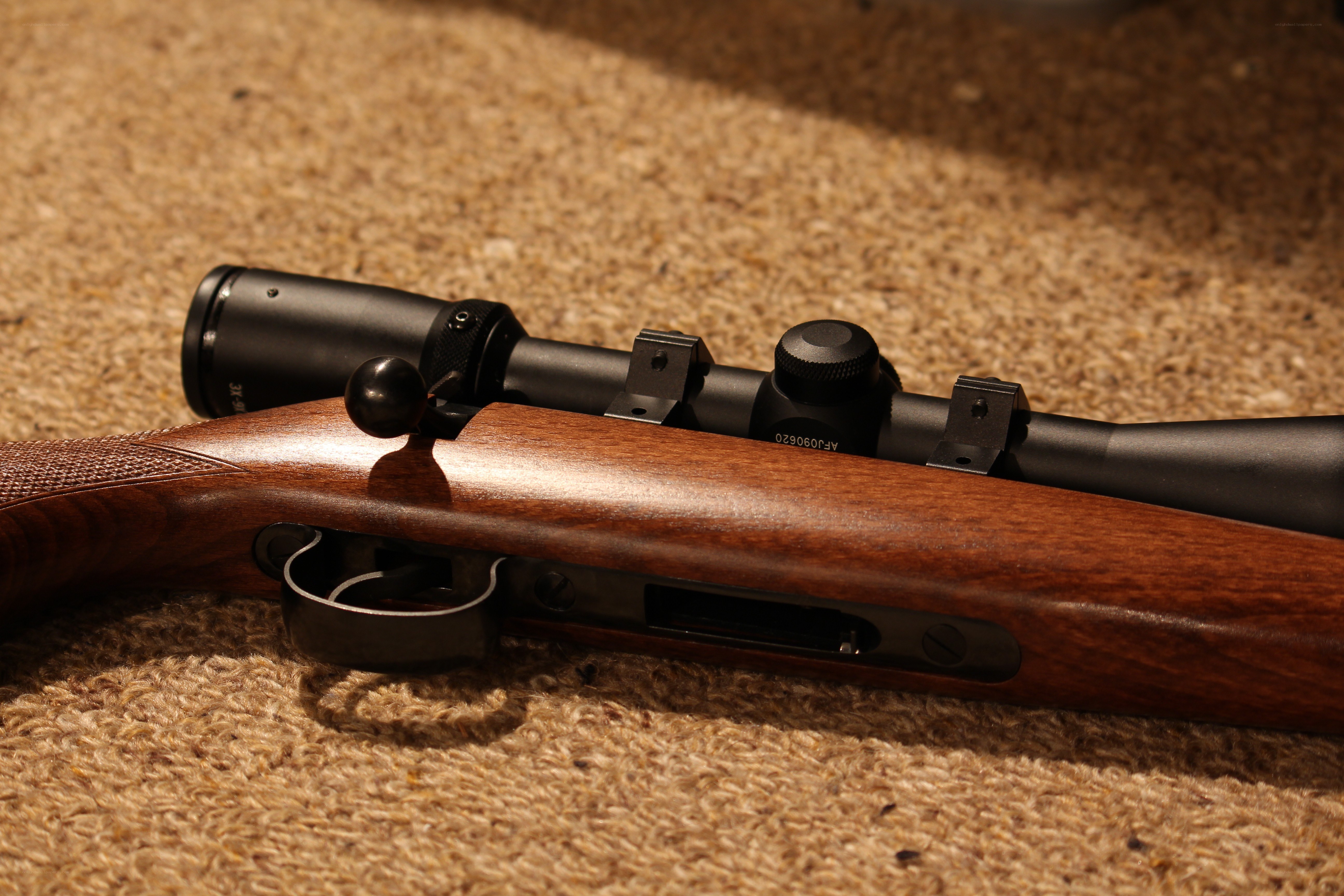 rifle with scope on carpet