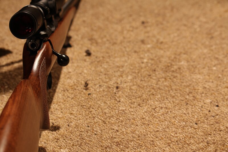 rifle with scope on carpet