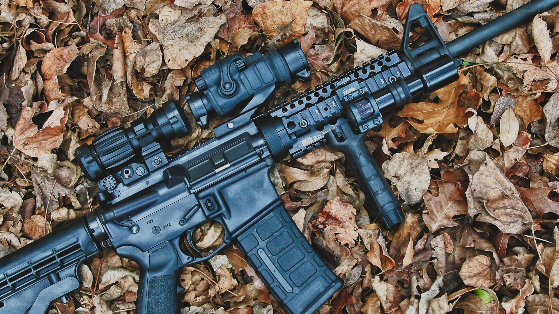 rifle with scope on leaves