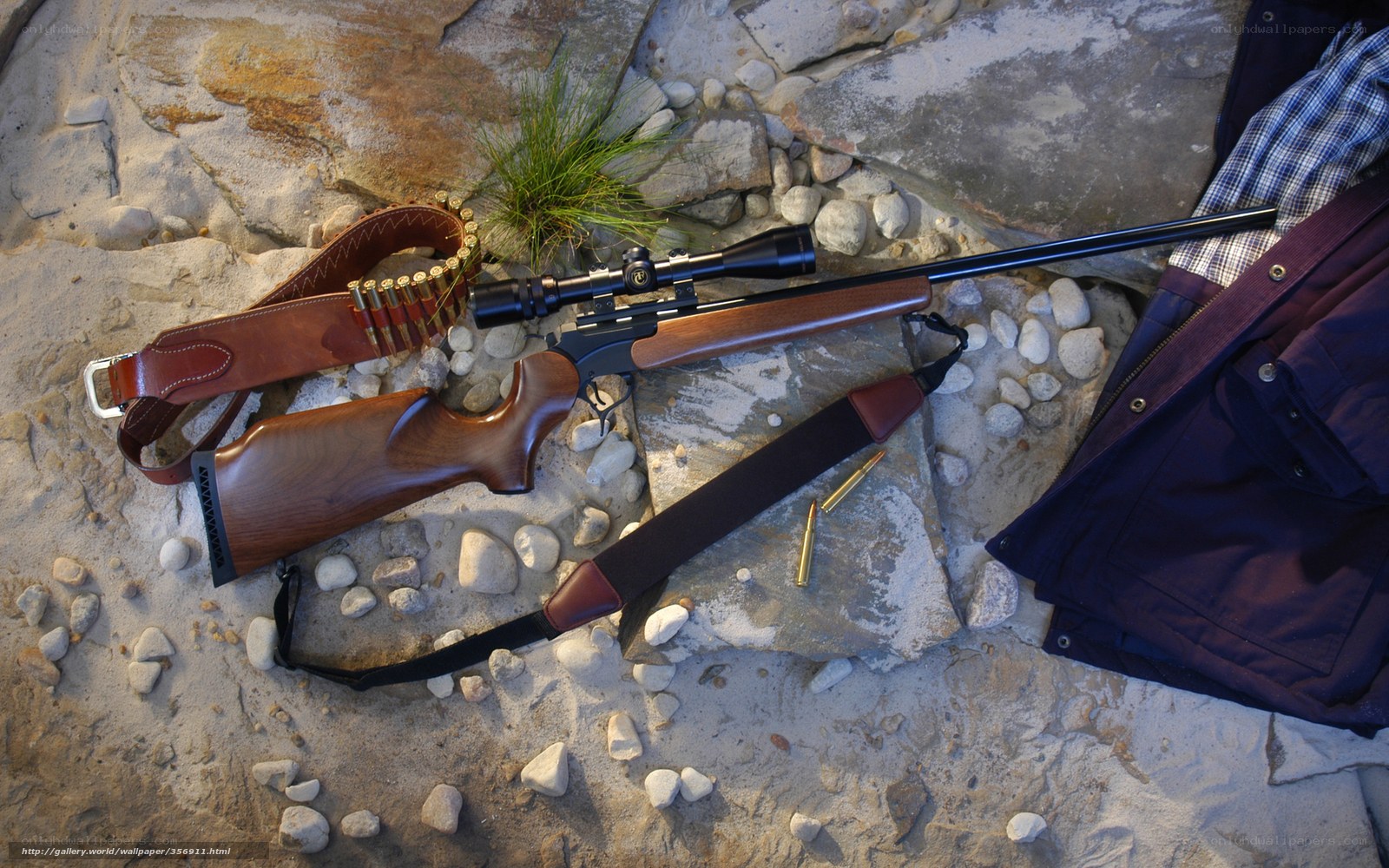 Rifle with scope on rocky ground