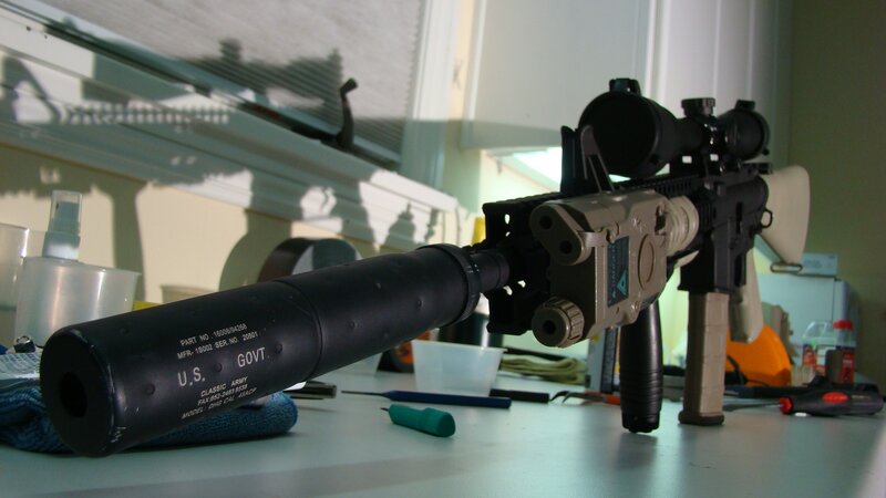 rifle with suppressor on table