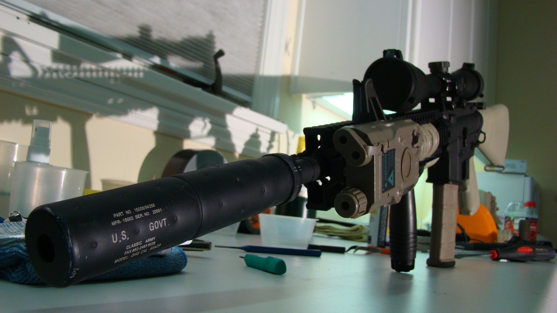 rifle with suppressor on table