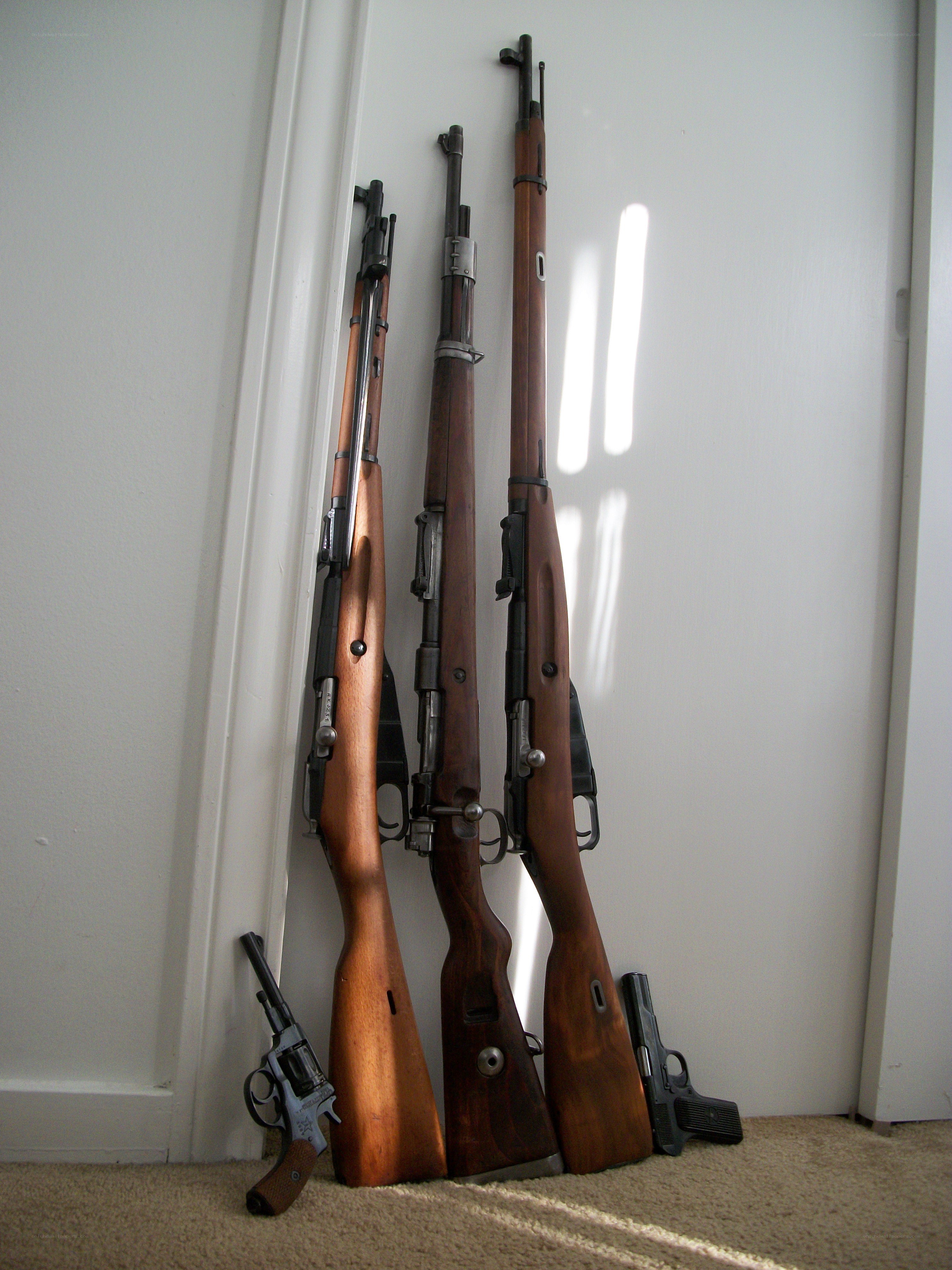 rifles and handguns against a wall