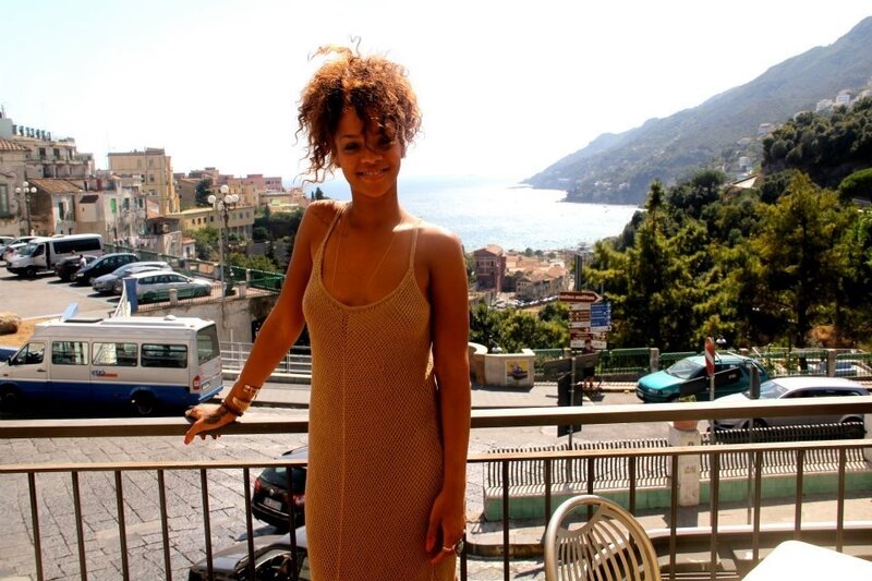 Rihanna on a balcony overlooking the coast