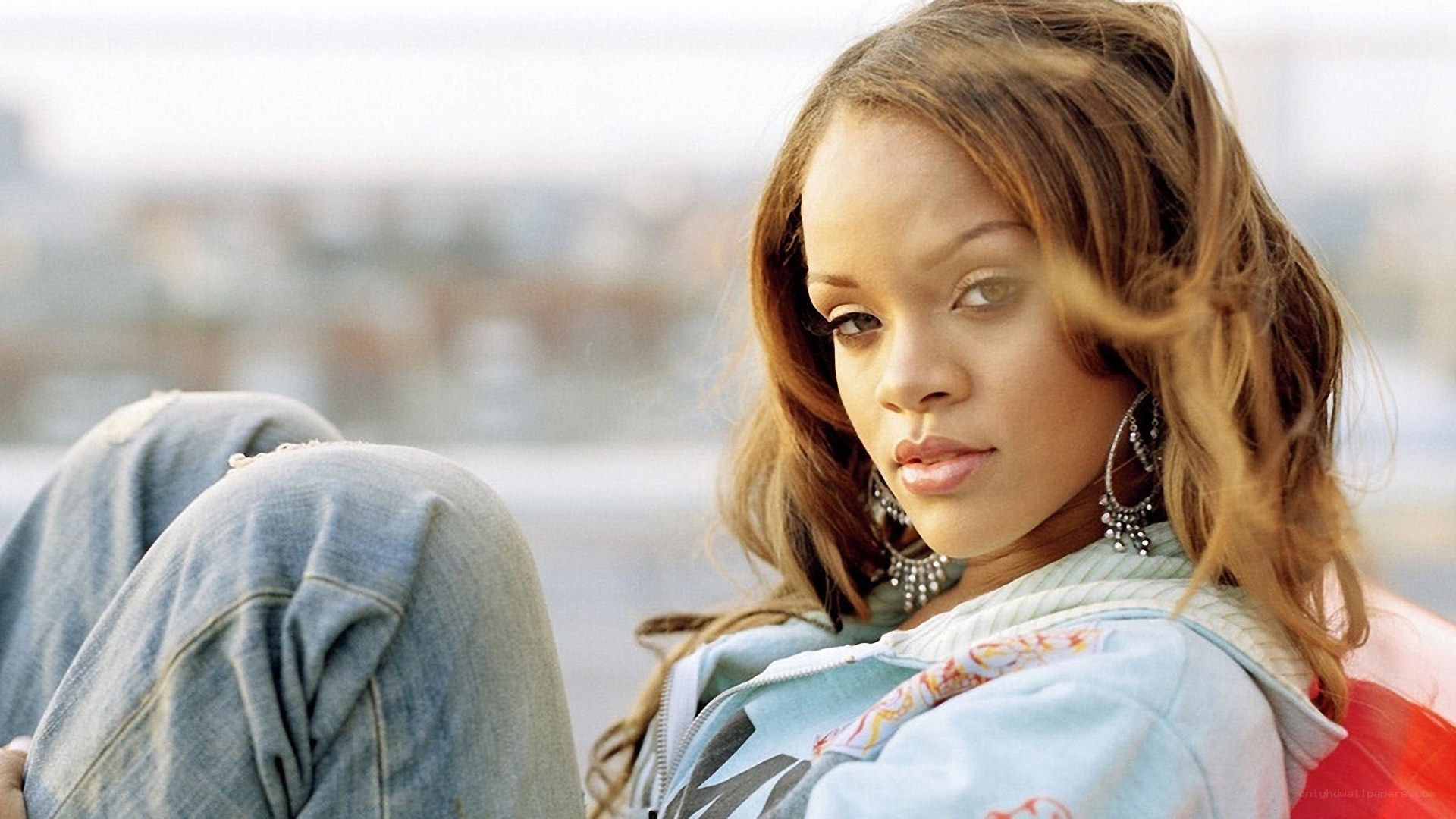 Rihanna sitting on a rooftop
