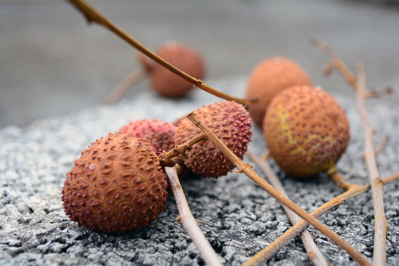 Ripe lychees on a stone surface