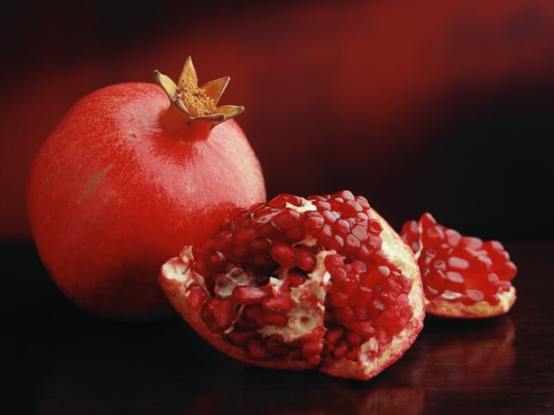 Ripe pomegranates on dark surface