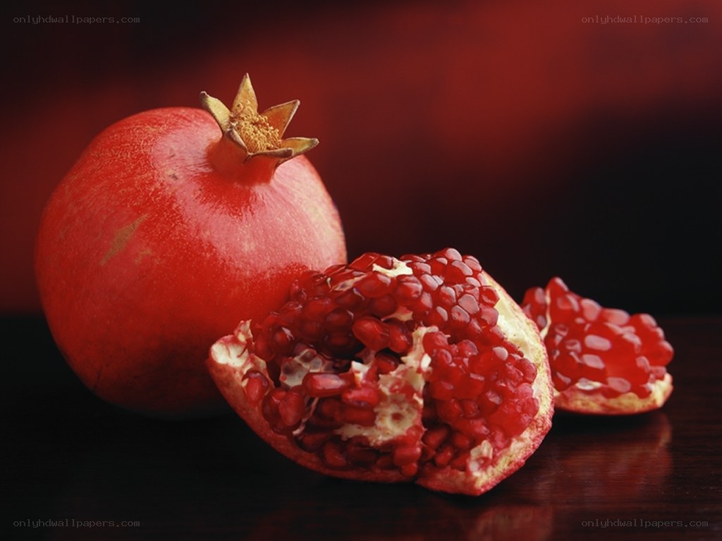 Ripe pomegranates on dark surface