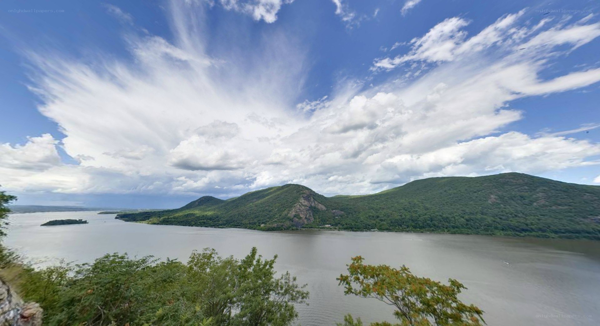 river and hills under cloudy sky