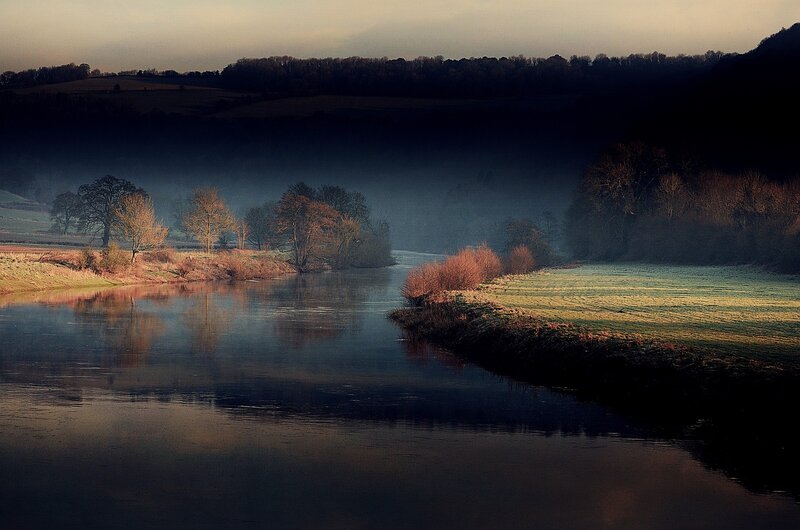 River at dawn in misty landscape