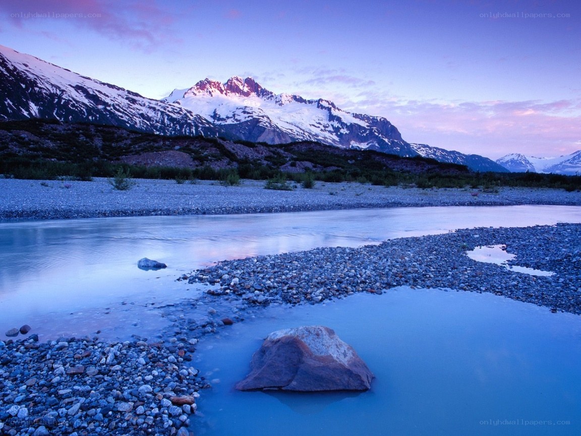 river at dusk with snow-capped mountains