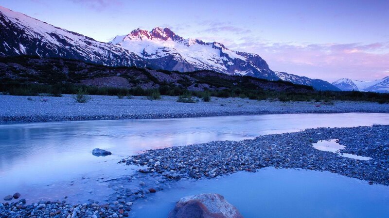 river at dusk with snow-capped mountains