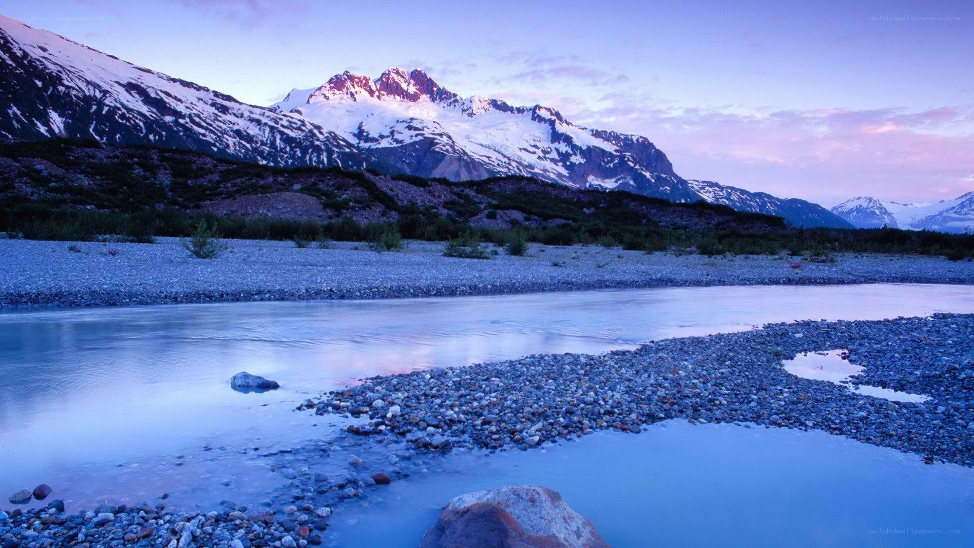river at dusk with snow-capped mountains