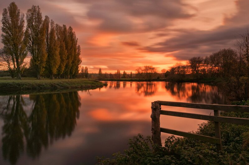 River at Sunset — Orange, Serene, Photograph, Trees, Fence, Sky, Pink
