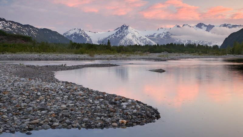 River at sunset with snow-capped mountains