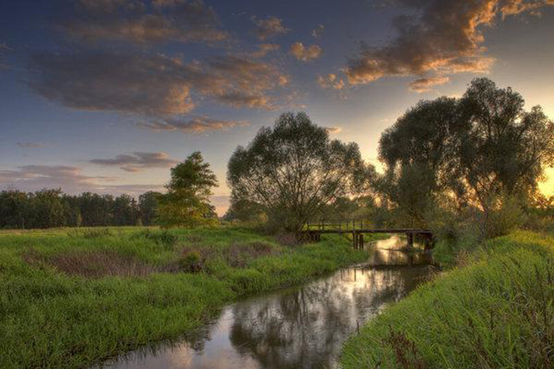 River at sunset with wooden bridge