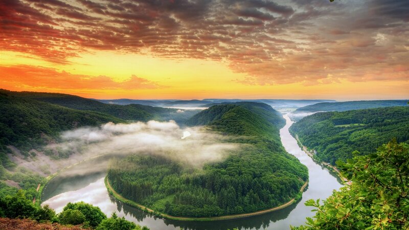 River bend at sunrise with fog