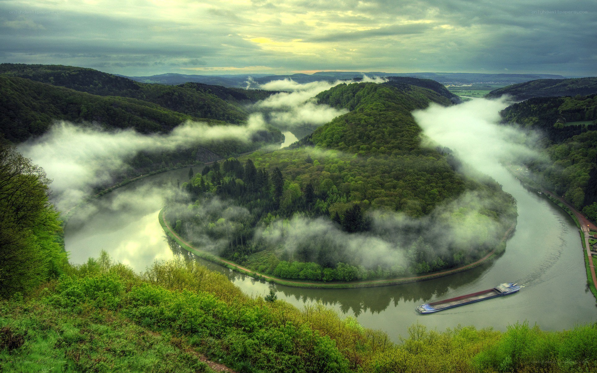 river bend with fog and barge