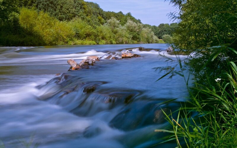 River Flowing over Rocks — Blue, Serene, Afternoon, Photograph, Trees, Grass, Green, White