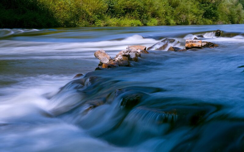 River Flowing over Rocks — Blue, Serene, Afternoon, Photograph, Trees, Water, Green