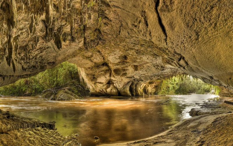 River Flowing Through Cave — Brown, Serene, Afternoon, Photograph, Trees, Rocks