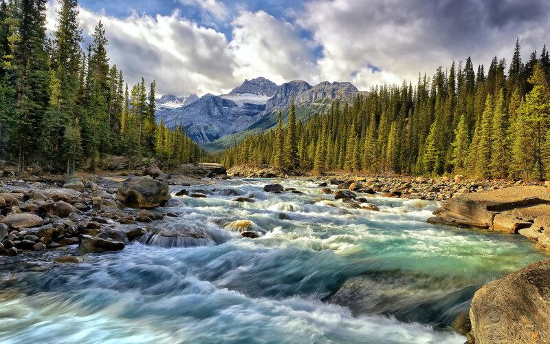 River Flowing Through Forest — Blue, Dramatic, Afternoon, Photograph, Mountains