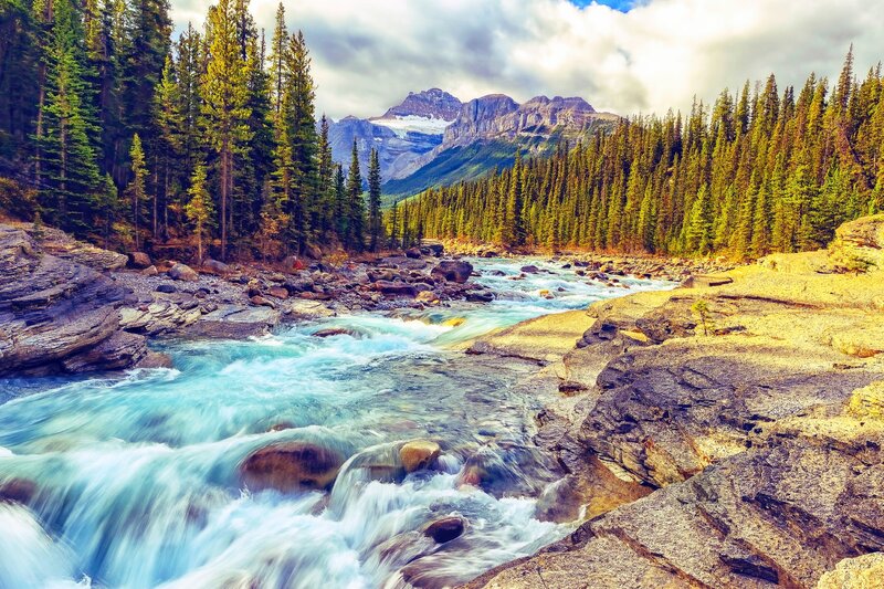 River Flowing Through Forest — Blue, Dramatic, Afternoon, Photograph, Mountains, Trees, Rocks