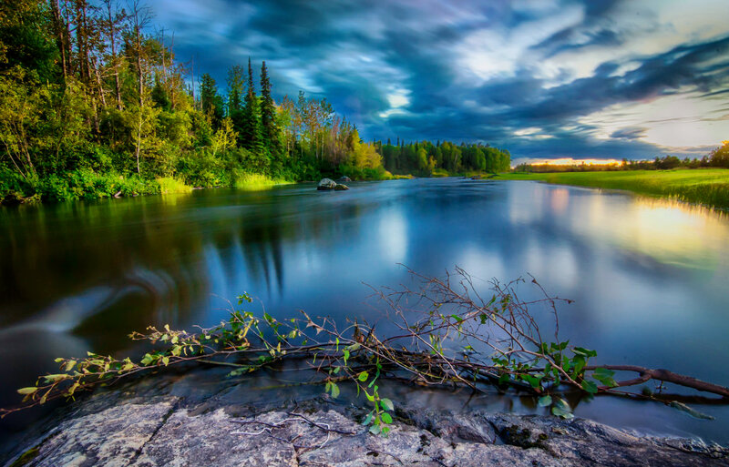 River Flowing Through Forest — Blue, Dramatic, Sunset, Photograph, Trees, Sky