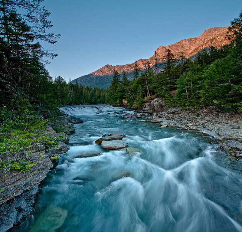 River Flowing Through Forest — Blue, Serene, Sunset, Photograph, Mountains