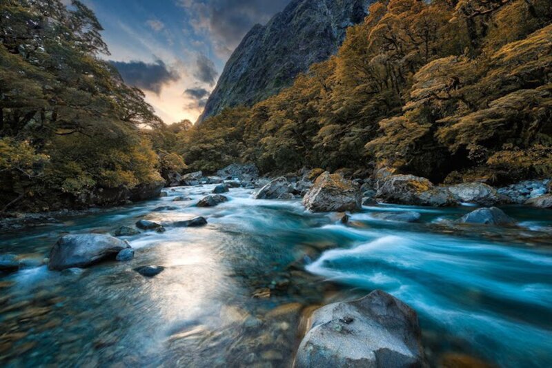 River Flowing Through Forest — Blue, Serene, Sunset, Photograph, Trees