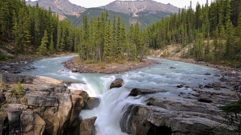 River Flowing Through Forest — Green, Serene, Afternoon, Photograph, Mountains, Trees, Rocks, Blue