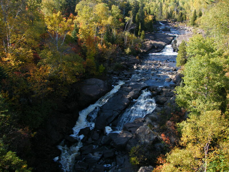 River Flowing Through Forest — Green, Serene, Autumn, Photograph, Trees, Rocks, Waterfall