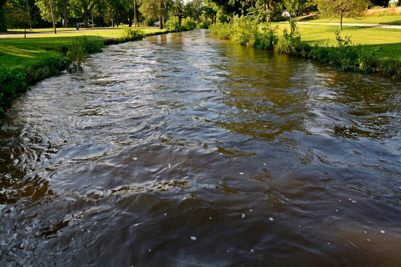 River Flowing Through Park — Green, Serene