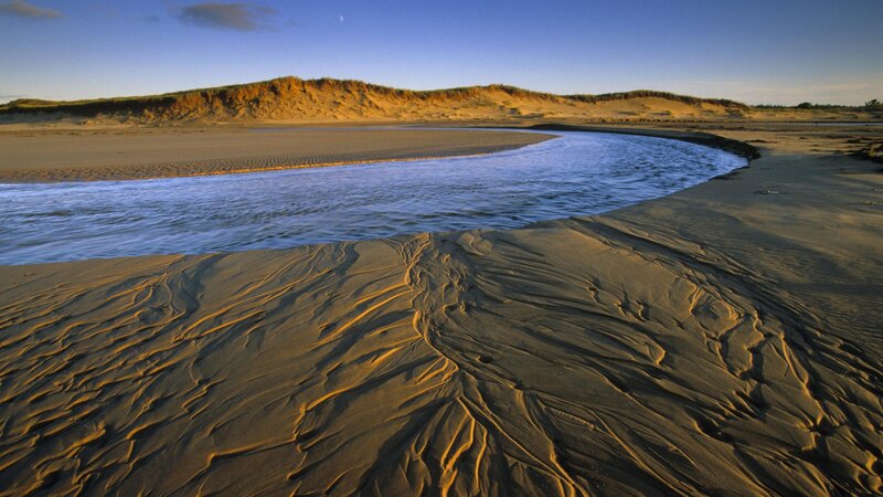 River flowing through sandy dunes
