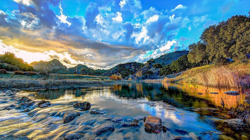 River Flowing Through Valley — Blue, Dramatic, Sunset, Photograph, Mountains, Trees, Sky
