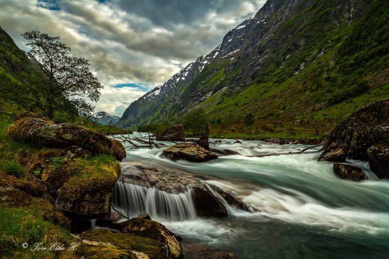 River Flowing Through Valley — Green, Dramatic, Afternoon, Photograph, Mountains