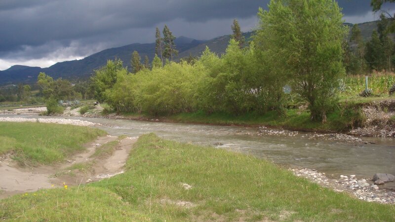 River Flowing Through Valley — Green, Dramatic, Afternoon, Photograph, Mountains, Trees, Clouds