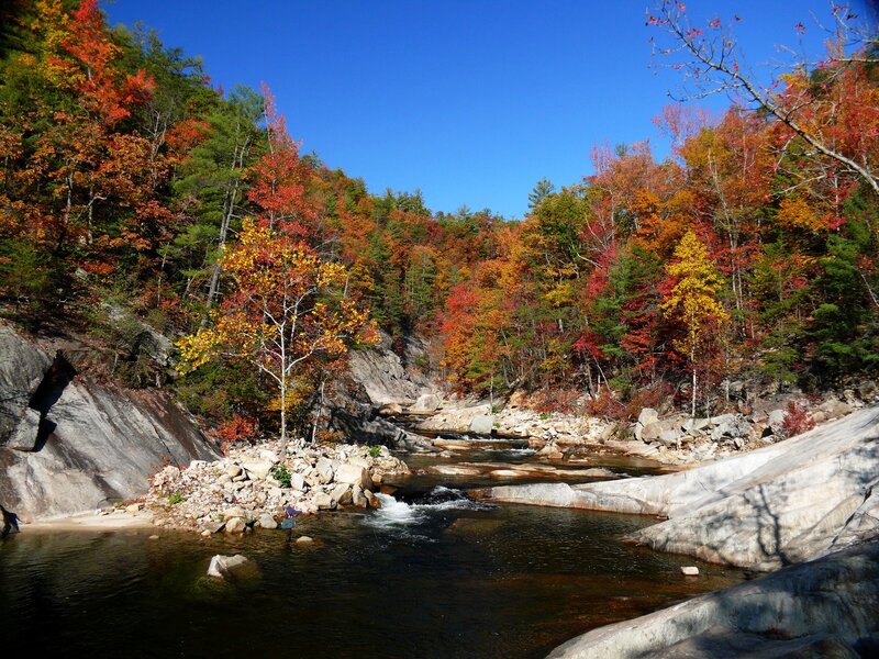 River in Autumn Forest — Blue, Serene, Photograph, Trees, Rocks, Person
