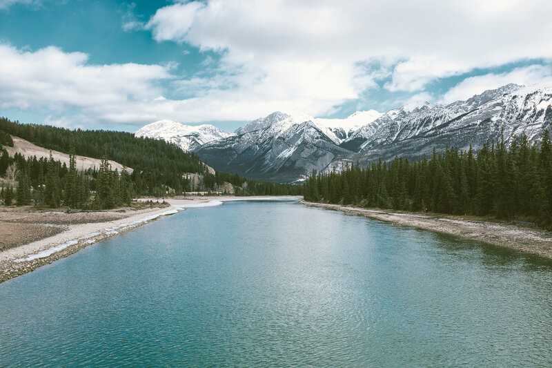 River in Mountain Valley — Blue, Serene, Afternoon, Photograph, Snow-capped Mountains, Evergreen Trees