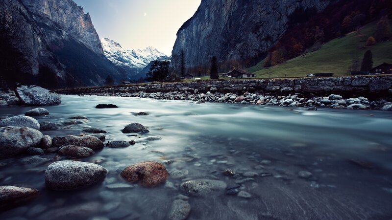 River in Mountain Valley — Blue, Serene, Morning, Photograph, Mountains, Rocks, Huts, Gray