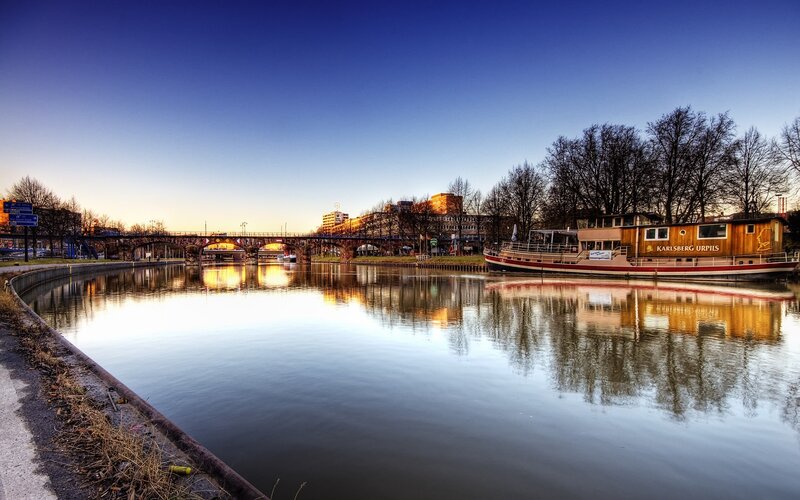 River scene at dusk with boat and bridge