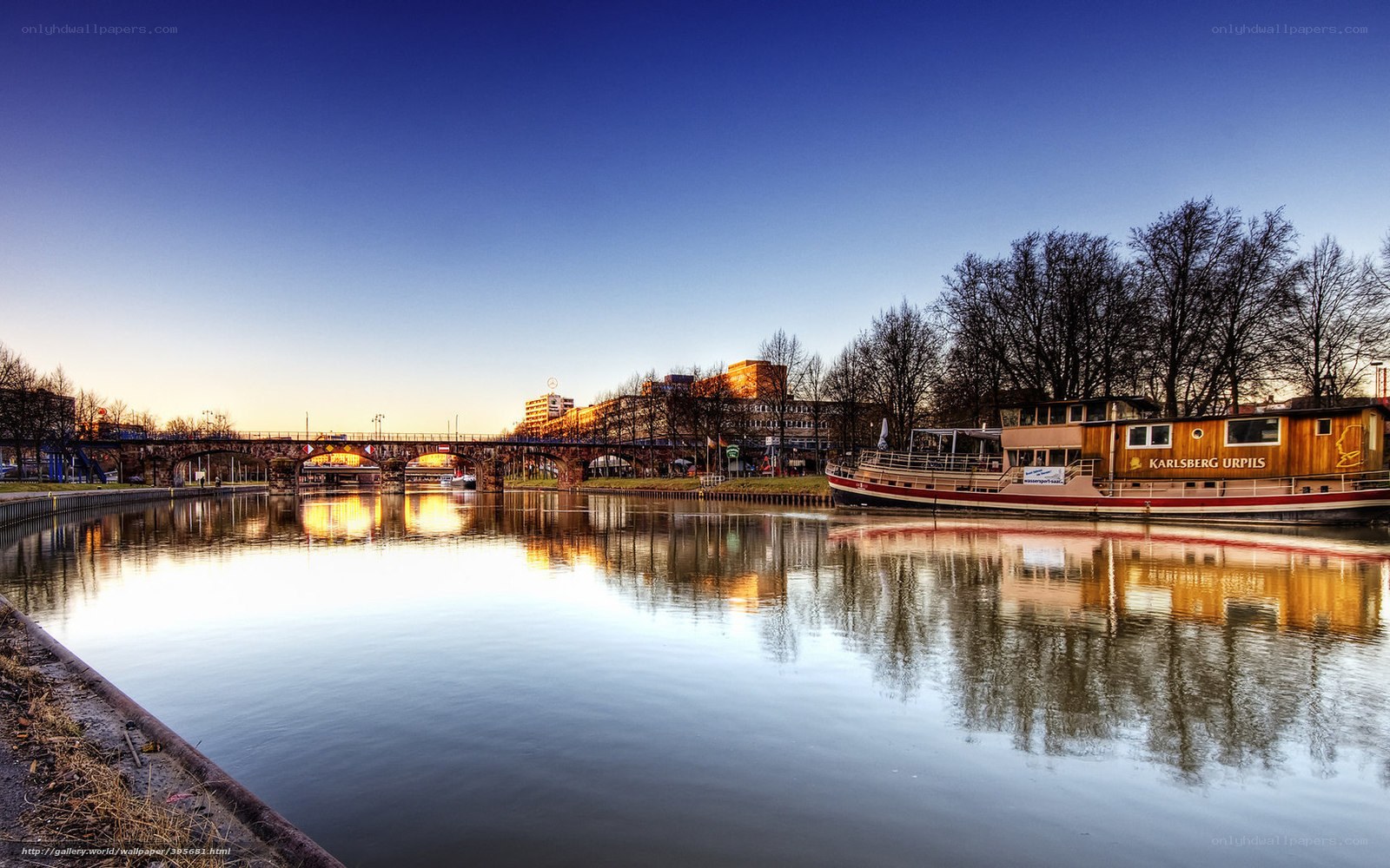 River scene at dusk with boat and bridge