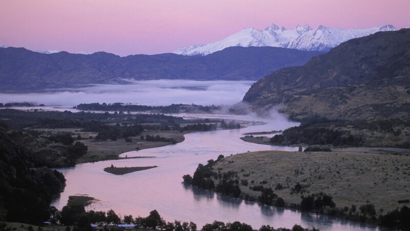 river valley at dawn with snow-capped mountains